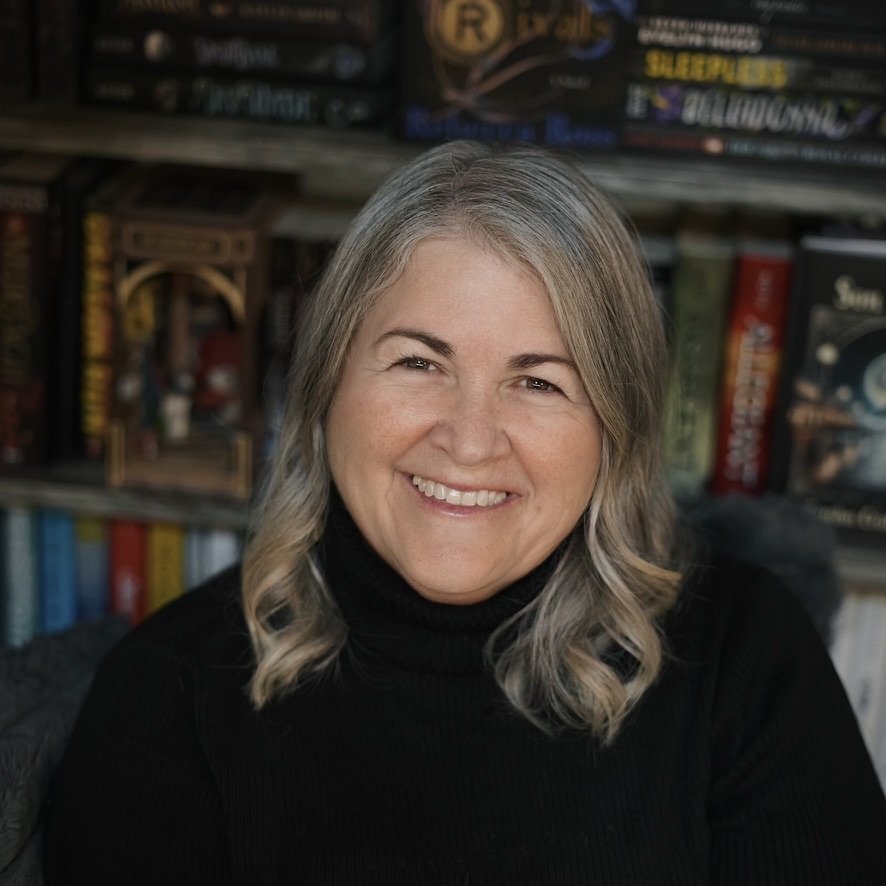 Author Carolyn Crislip-Tacy smiling in front of a bookshelf
